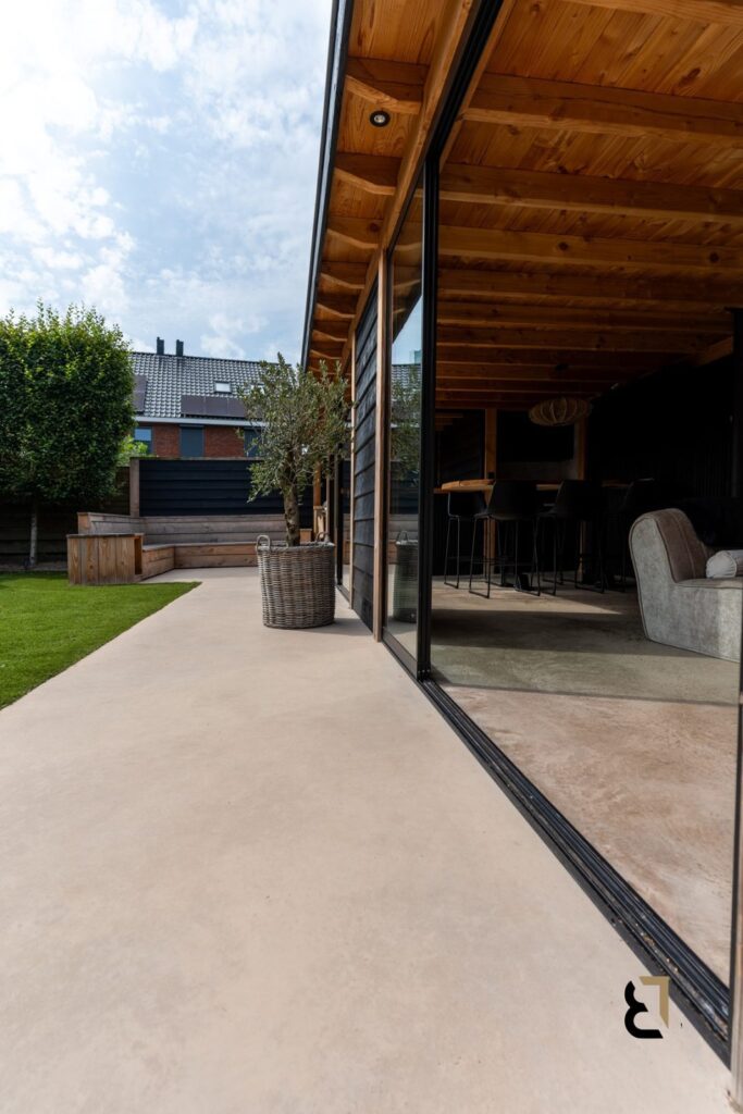 Tuinhuis met woonbetonvloer en terras van woonbeton. Verschillen tussen de twee soorten vloeren zijn goed te zien.