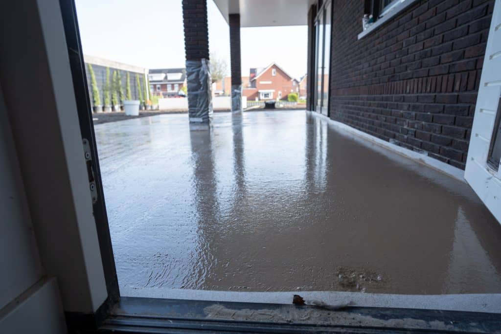 Storten van woonbeton voor het maken van een betonnen oprit bij een woning in Heerhugowaard