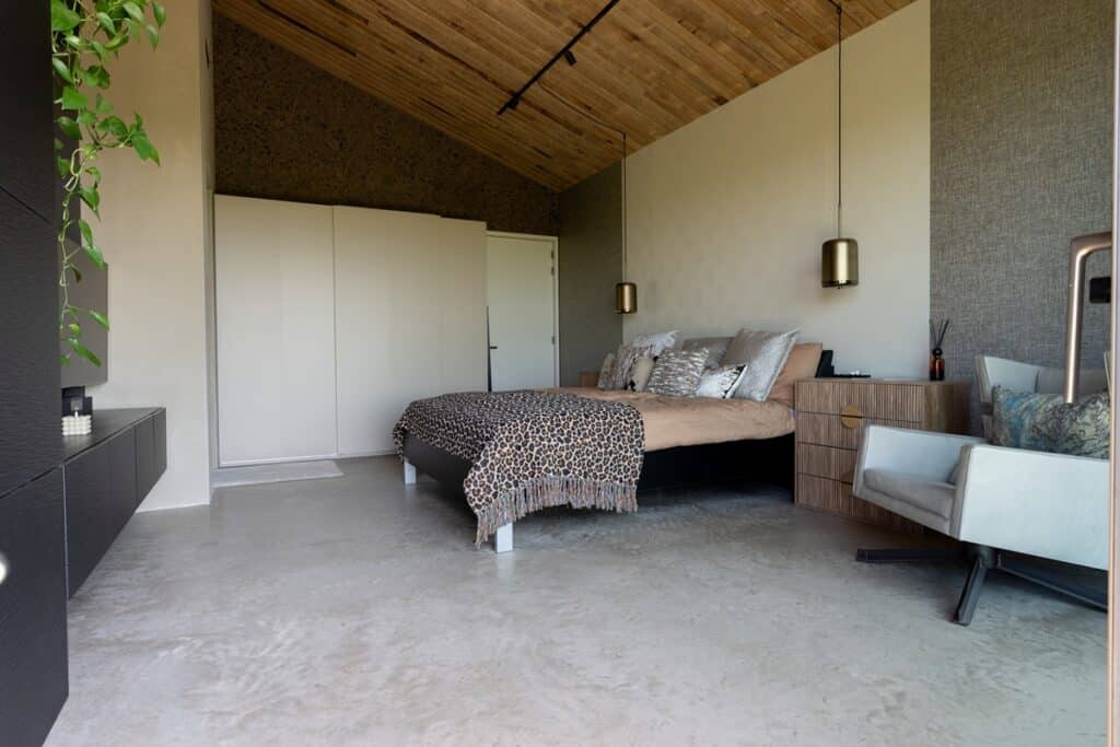 Sfeervolle, bohemian stijl slaapkamer met woonbetonvloer in Noord-Holland